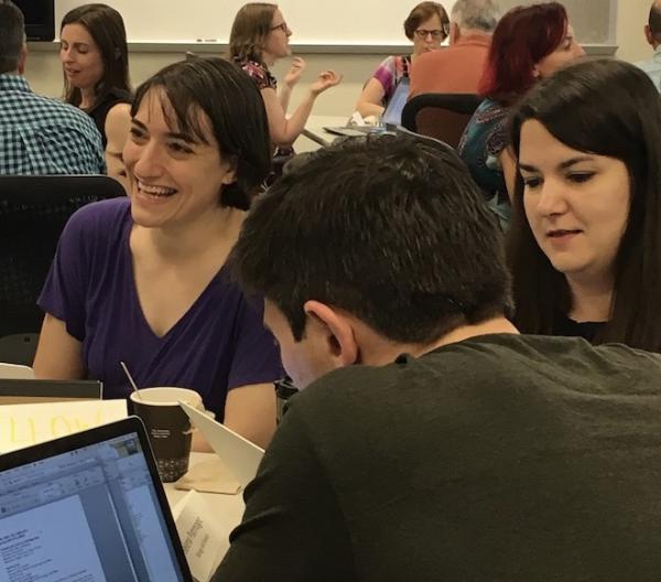 Several CDI participants work on syllabi at tables